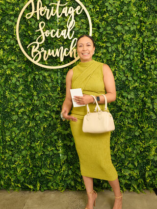 A guest poses at the Heritage Social Brunch welcome wall