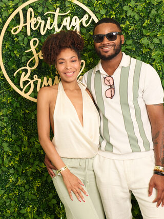 Two guests pose at the Heritage Social Brunch welcome wall