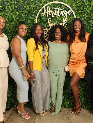 A group of guests pose at the Heritage Social Brunch welcome wall