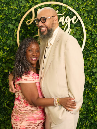 Two guests embrace at the Heritage Social Brunch welcome wall
